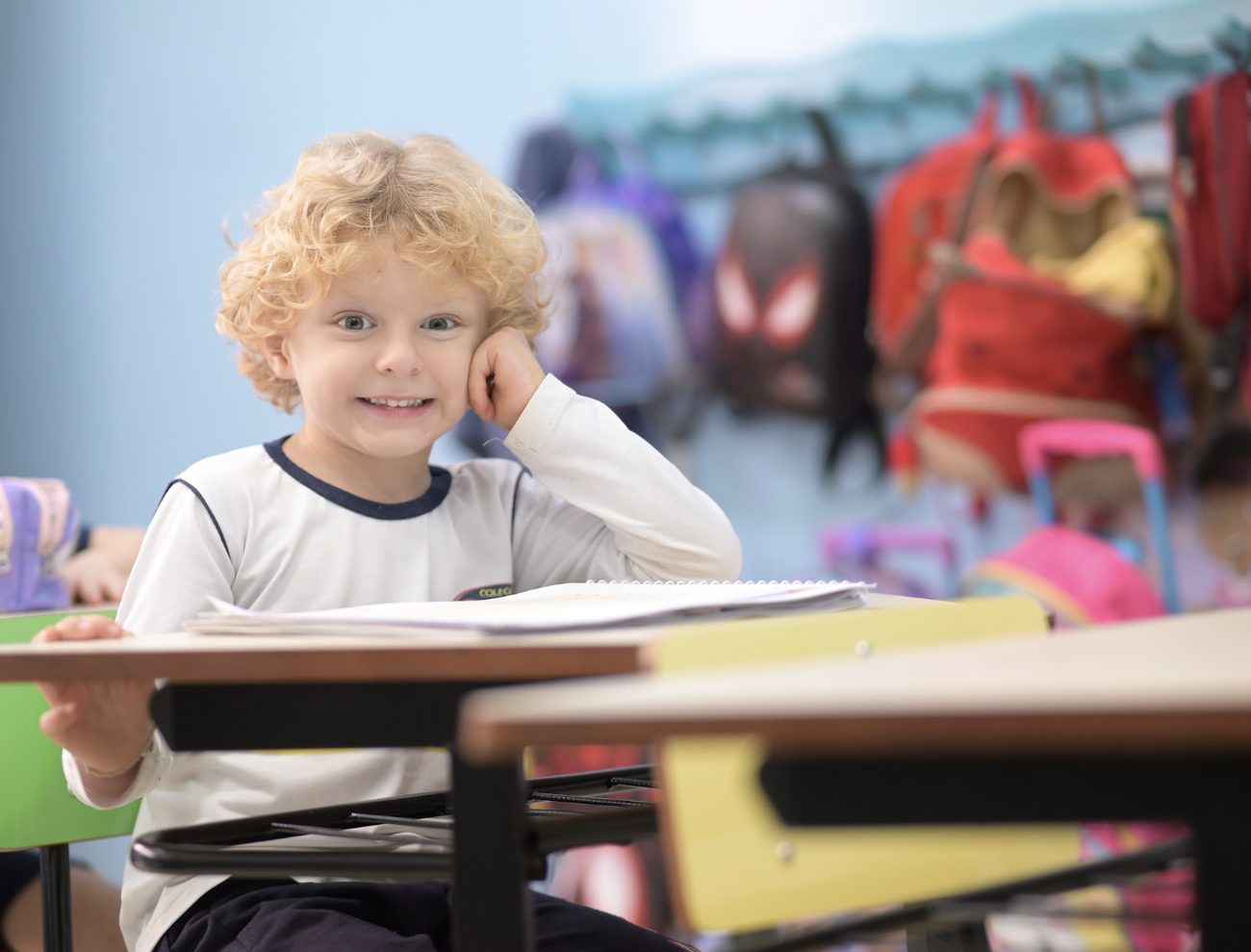 Criança da Educação Infantil sorrindo em sala de aula